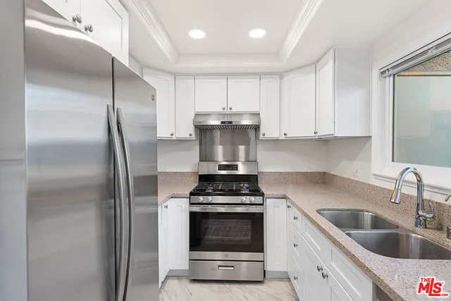 a kitchen with refrigerator a stove a sink and cabinets