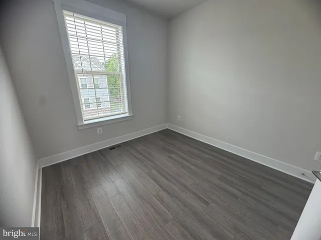 an empty room with wooden floor and closet