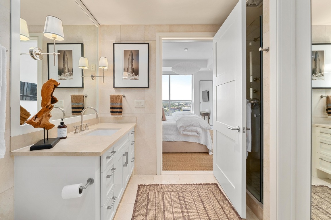 98 San Jacinto Boulevard, Unit 1201 Austin, TX 78701 - Photo 13 of 22 a en suite bathroom with a sink and a mirror