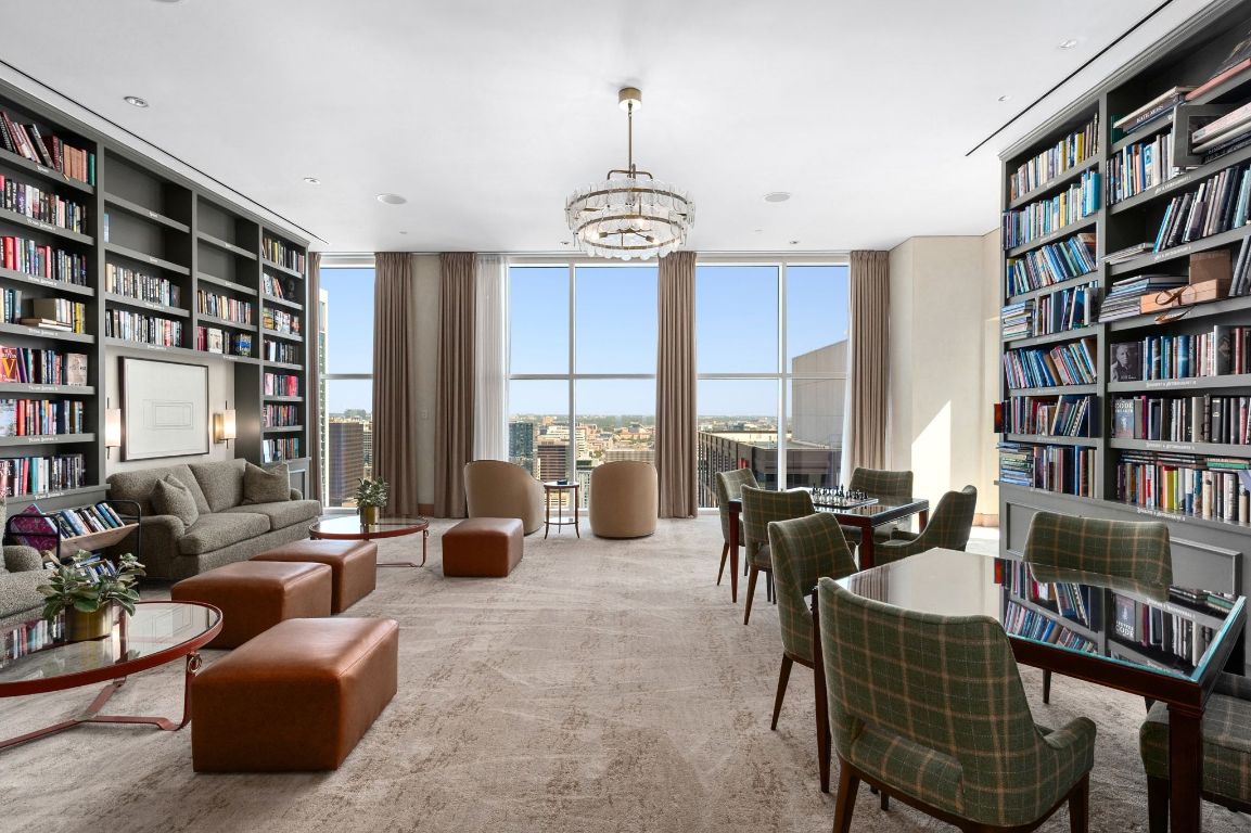 98 San Jacinto Boulevard, Unit 1201 Austin, TX 78701 - Photo 21 of 22 a living room with furniture and a book shelf
