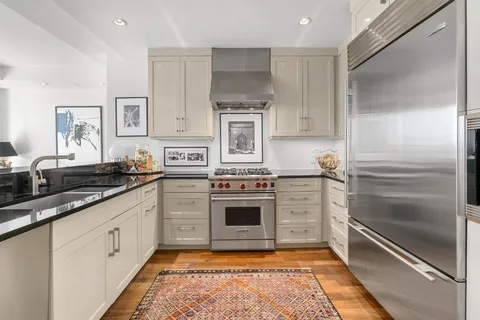 a kitchen with white cabinets and stainless steel appliances