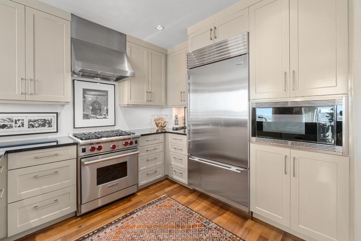 98 San Jacinto Boulevard, Unit 1201 Austin, TX 78701 - Photo 8 of 22 a kitchen with white cabinets and stainless steel appliances