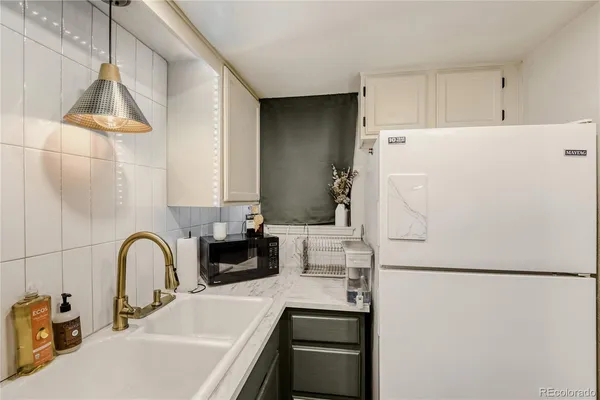 a close view of a sink and a refrigerator in a kitchen