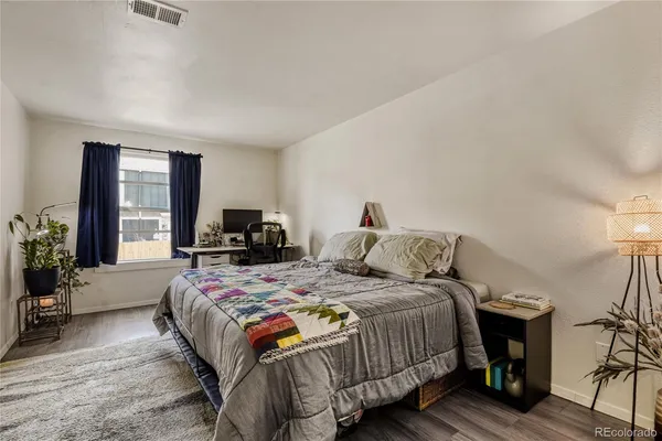 a bedroom with a bed and wooden floor