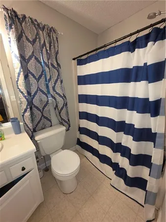 a white toilet sitting next to a shower curtain
