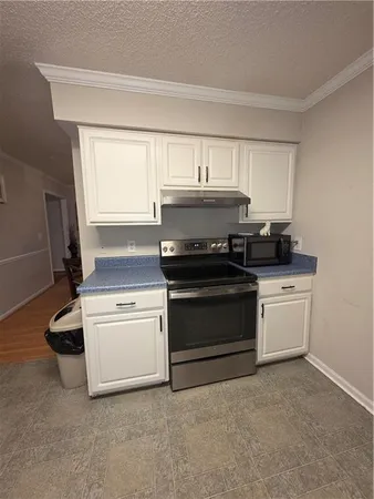 a kitchen with a stove and white cabinets