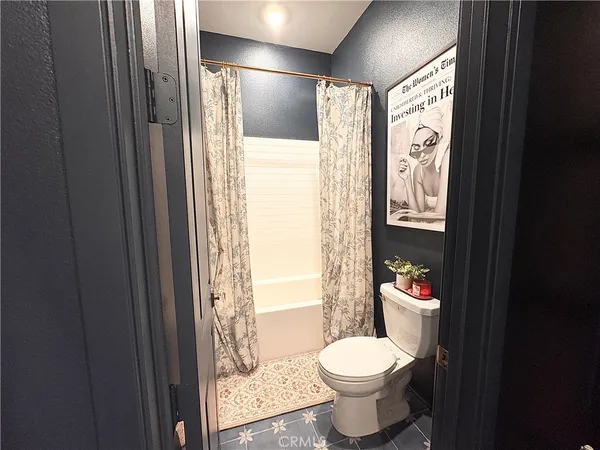 a bathroom with a toilet and a shower curtain