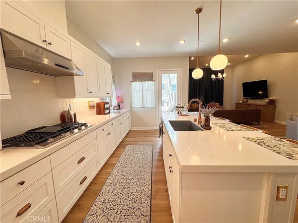 a large kitchen with kitchen island a stove a sink a center island and windows