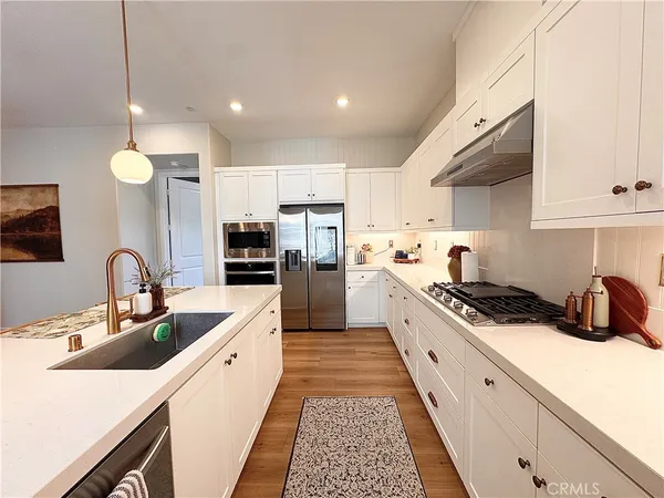 a large kitchen with stainless steel appliances granite countertop a sink and cabinets