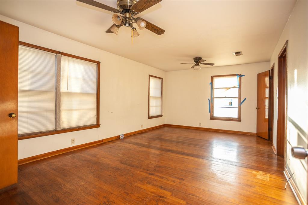 1414 Rice Avenue Gainesville, TX 76240 - Photo 11 of 21 a view of an empty room with a window and wooden floor