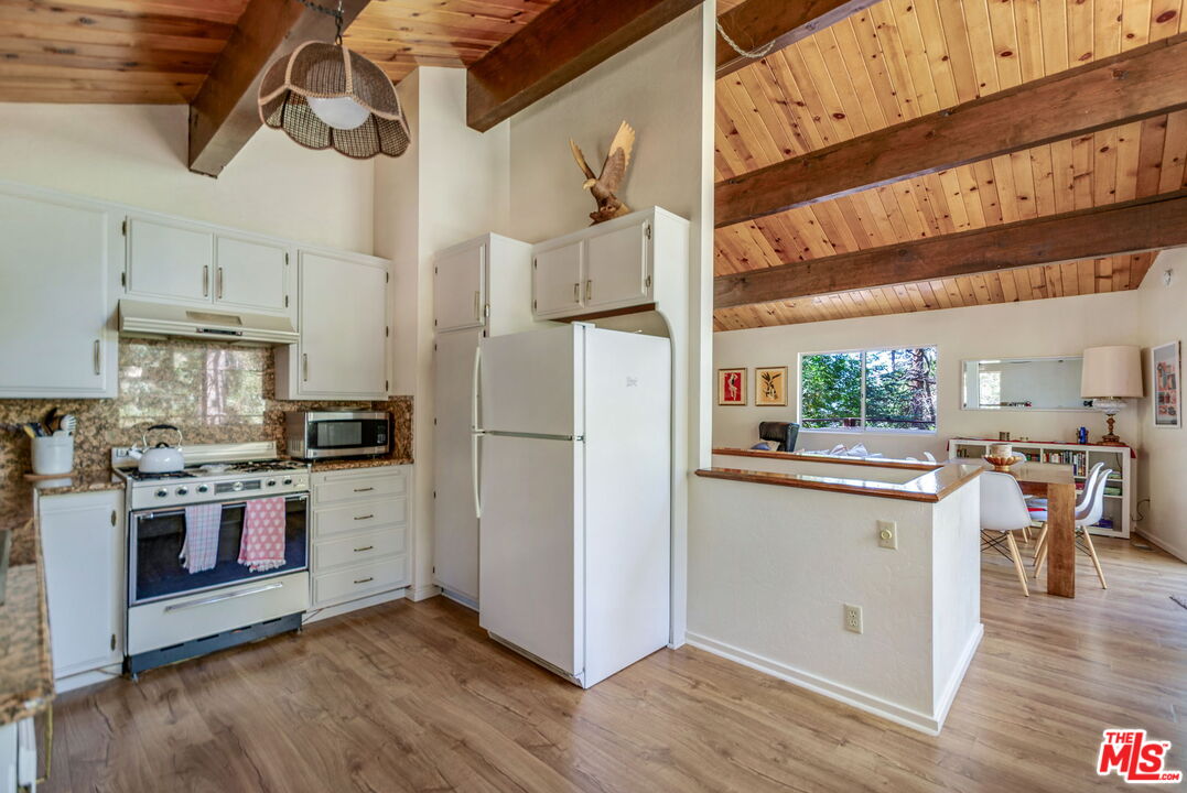 2378 Rim Of The World Drive Running Springs, CA 92382 - Photo 13 of 33 a kitchen with cabinets and wooden floor