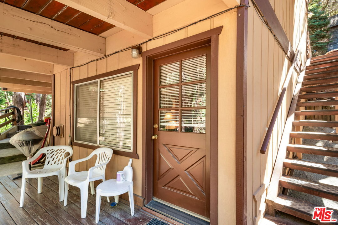 2378 Rim Of The World Drive Running Springs, CA 92382 - Photo 22 of 33 a view of a patio with table and chairs and wooden floor