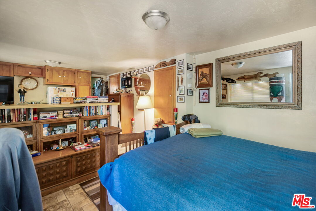 2378 Rim Of The World Drive Running Springs, CA 92382 - Photo 23 of 33 a room with lots of wooden furniture and a book shelf
