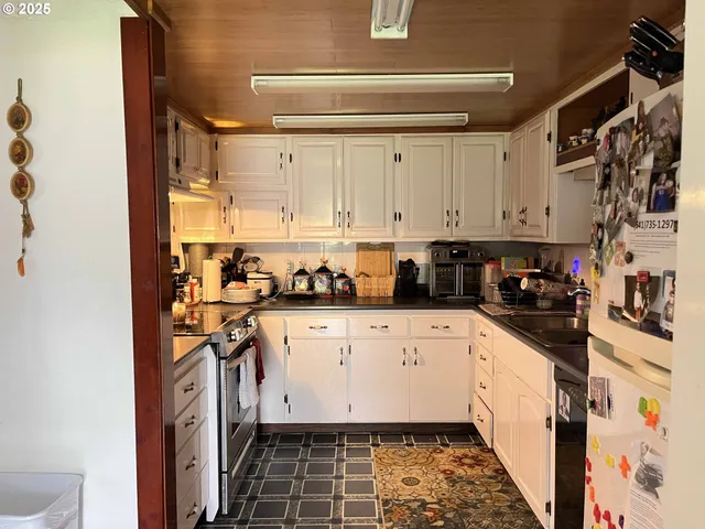 a kitchen with stainless steel appliances granite countertop a refrigerator and white cabinets