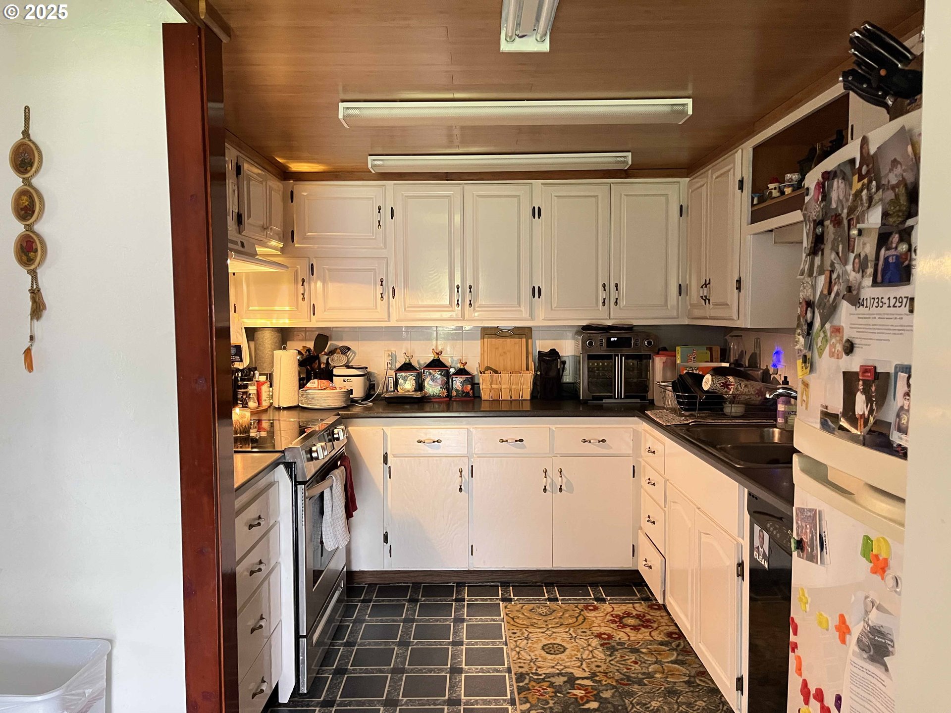 2385 19th Street Florence, OR 97439 - Photo 13 of 47 a kitchen with stainless steel appliances granite countertop a refrigerator and white cabinets