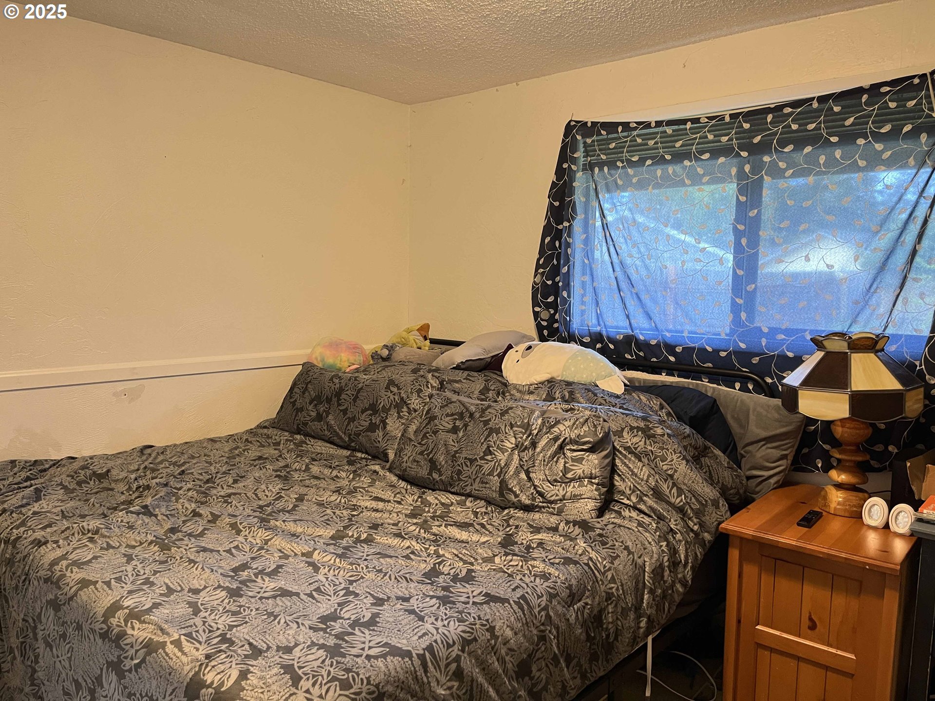2385 19th Street Florence, OR 97439 - Photo 28 of 47 a bed sitting in a bedroom next to a lamp