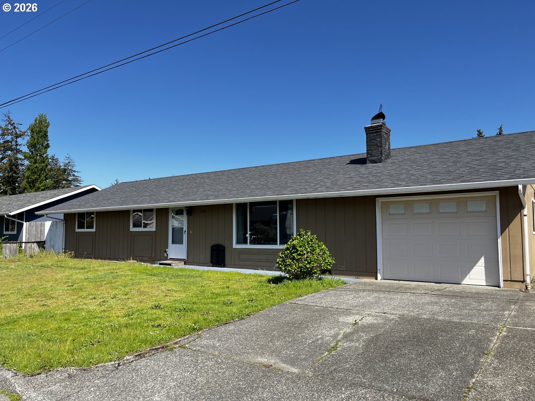 2385 19th Street Florence, OR 97439 - Photo 47 of 47 a front view of a house with a yard and garage