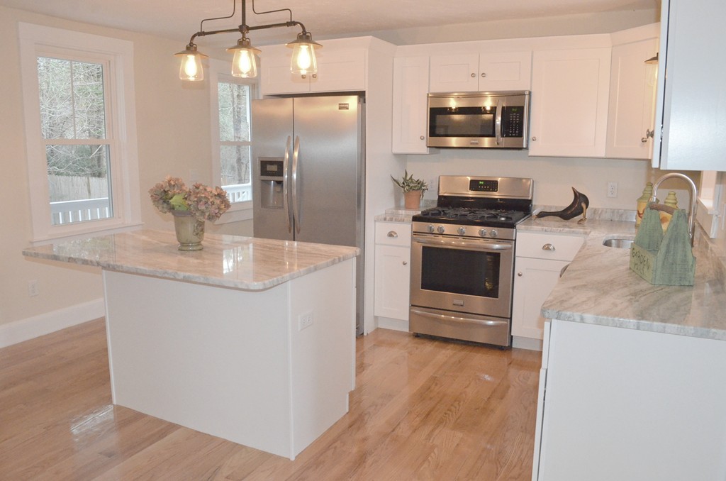 144 Pleasant Street Raynham, MA 02767 - Photo 18 of 29 a kitchen with stainless steel appliances granite countertop a sink a stove and a refrigerator
