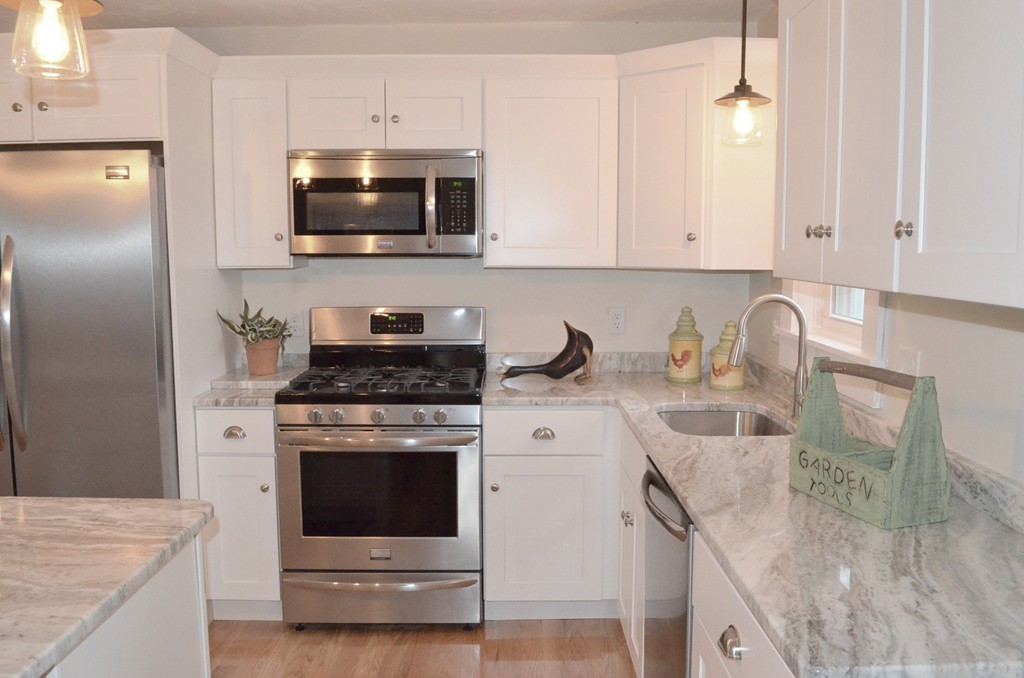 144 Pleasant Street Raynham, MA 02767 - Photo 20 of 29 a kitchen with granite countertop a stove sink and microwave