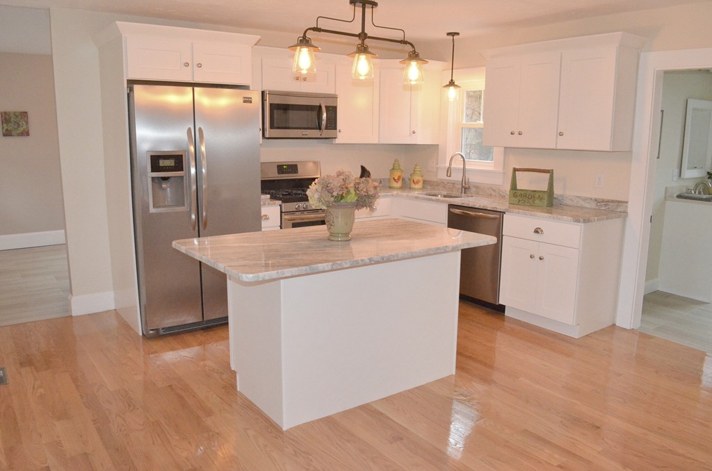 144 Pleasant Street Raynham, MA 02767 - Photo 22 of 29 a kitchen with stainless steel appliances granite countertop a refrigerator a sink a stove and white cabinets