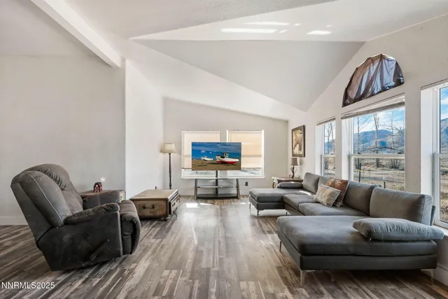 a living room with furniture a flat screen tv and a floor to ceiling window