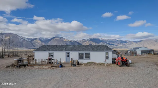 a view of a house with a patio and a car parked in front of it