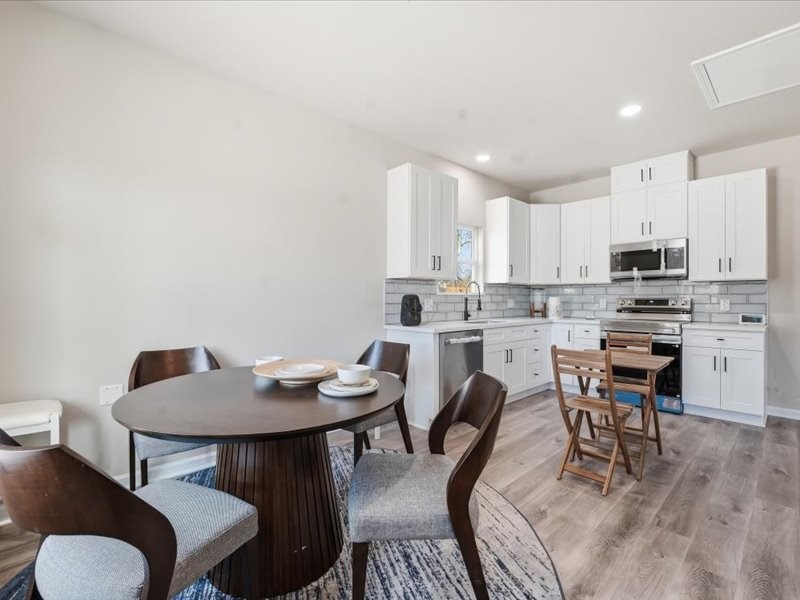 8708 Wileyvale Road Houston, TX 77016 - Photo 7 of 23 a kitchen with stainless steel appliances kitchen island granite countertop a dining table chairs and a refrigerator