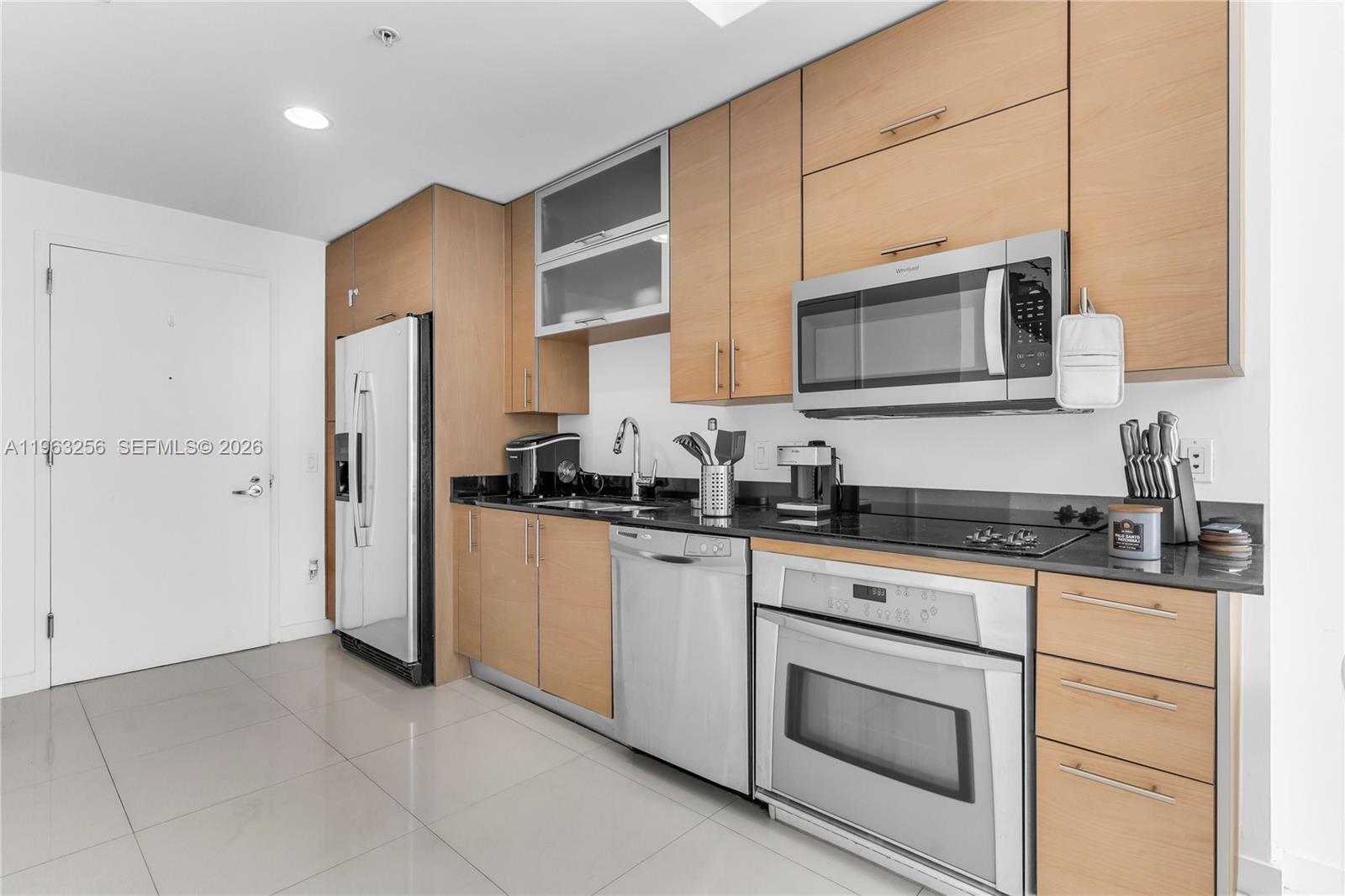 60 Southwest 13th Street, Unit 3416 Miami, FL 33130 - Photo 9 of 20 a kitchen with stainless steel appliances granite countertop white cabinets a sink a stove a refrigerator and white cabinets