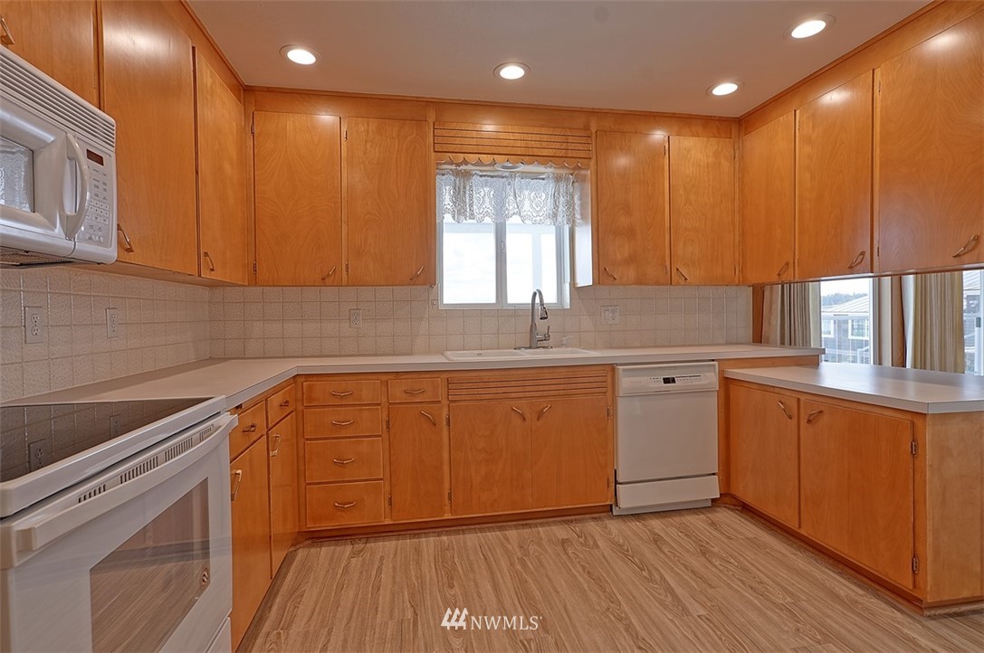 2017 Vernon Road Lake Stevens, WA 98258 - Photo 15 of 25 a kitchen with stainless steel appliances granite countertop a sink a stove cabinets and wooden floor