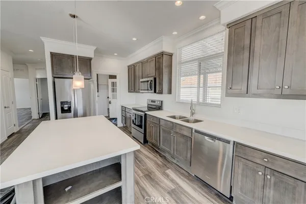a large kitchen with kitchen island a sink stainless steel appliances and cabinets