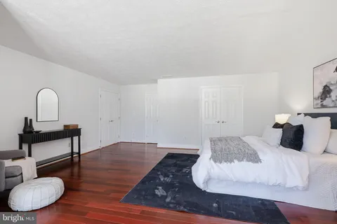 a bedroom with a bed a couch and a potted plant