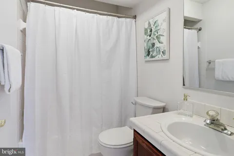 a bathroom with a sink toilet and a mirror