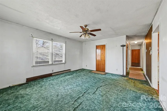 an empty room with fan and windows