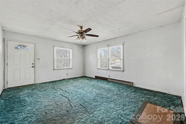 a view of a room with window and ceiling fan