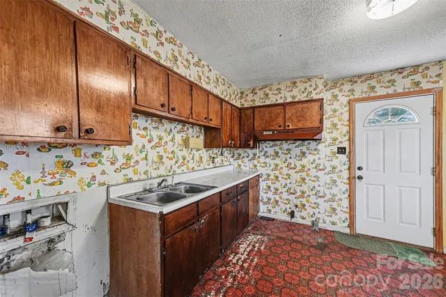a kitchen with stainless steel appliances a stove a sink and a microwave