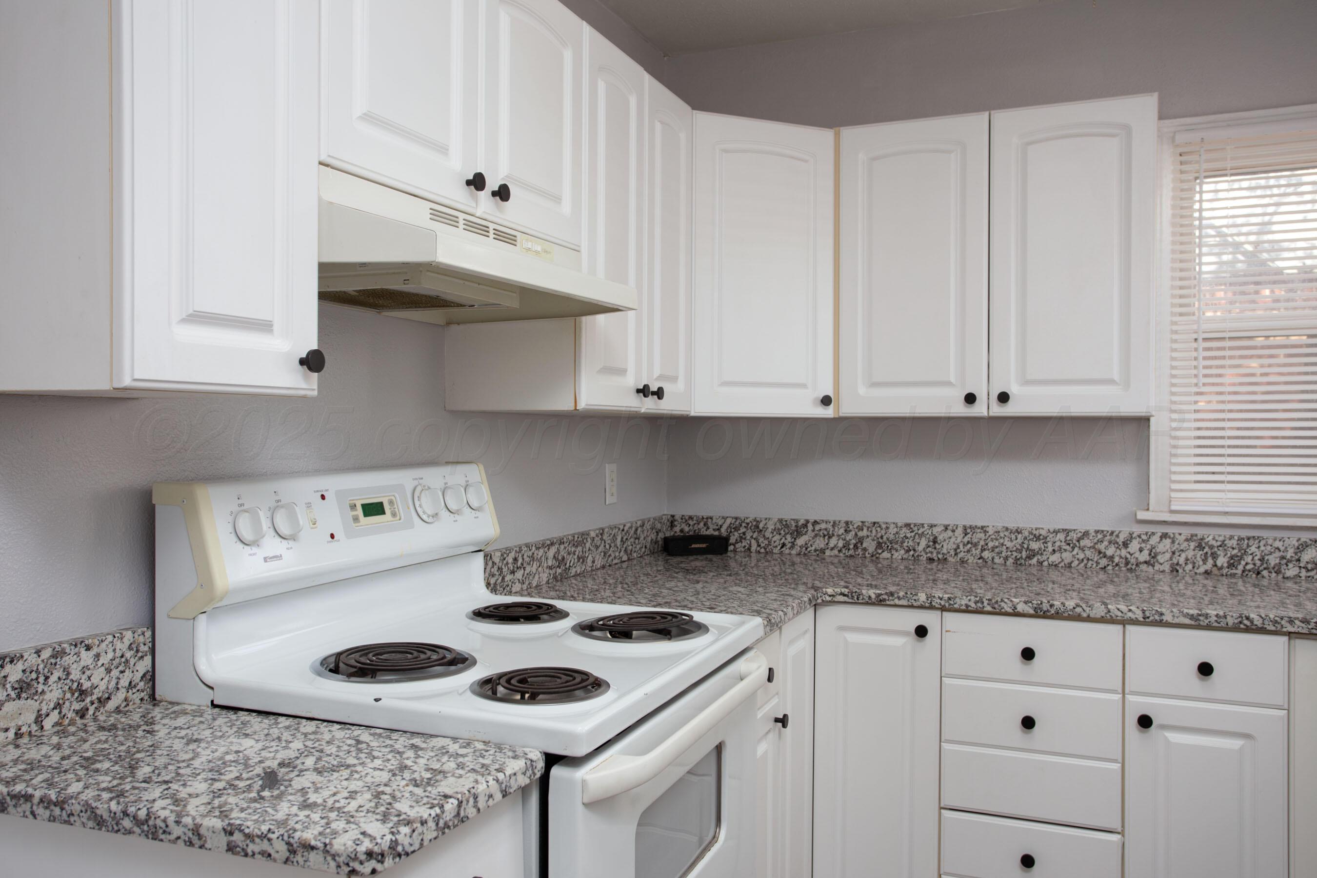 4215 South Travis Street Amarillo, TX 79110 - Photo 13 of 20 a kitchen with white cabinets and white appliances