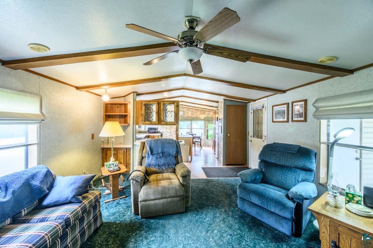705 4th Street North Biwabik, MN 55708 - Photo 8 of 29 Living area featuring vaulted ceilings with exposed wood-finish beams and a ceiling fan