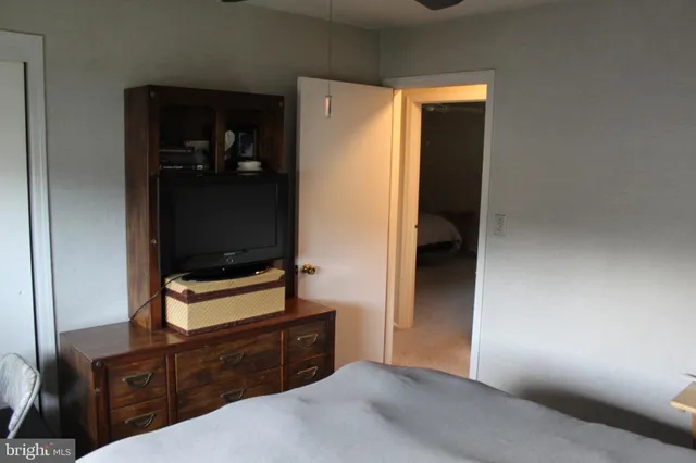 a bedroom with a bed and a flat tv screen on a dresser