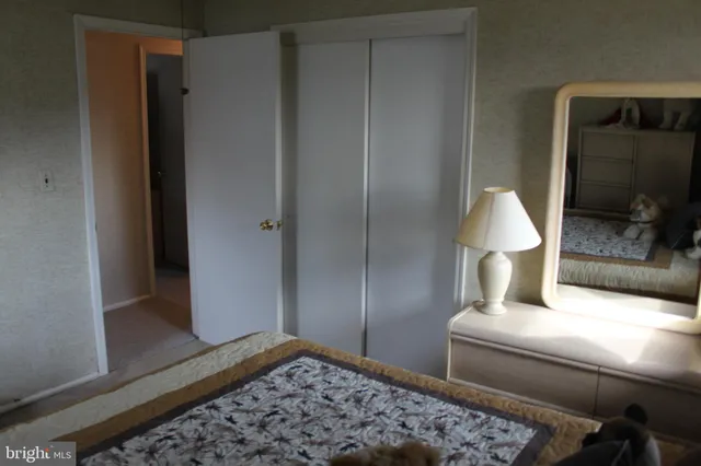 a living room with a bed and a mirror on dresser