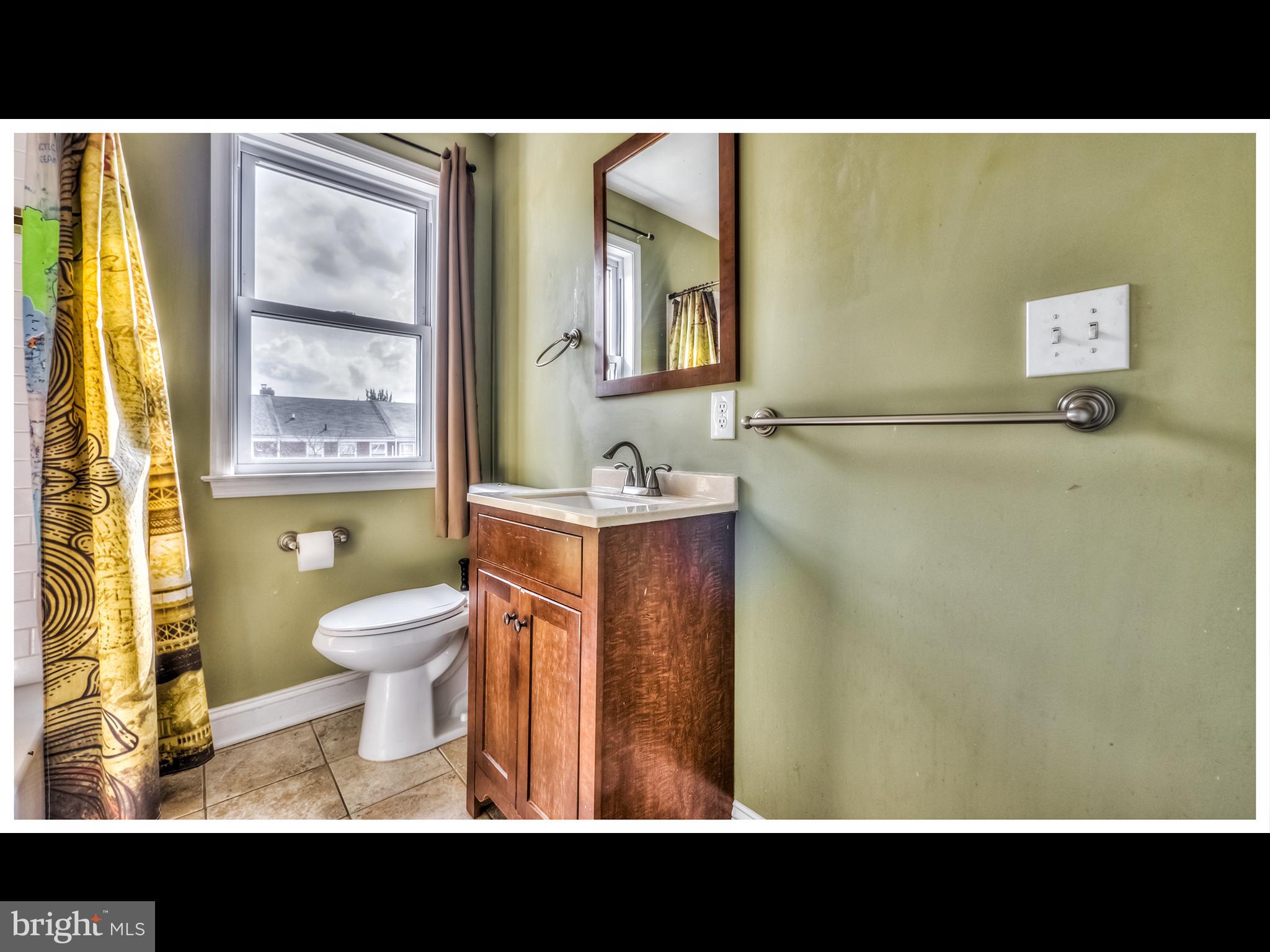 836 Bradhurst Road Baltimore, MD 21212 - Photo 14 of 24 a view of a bathroom with a toilet sink and a mirror