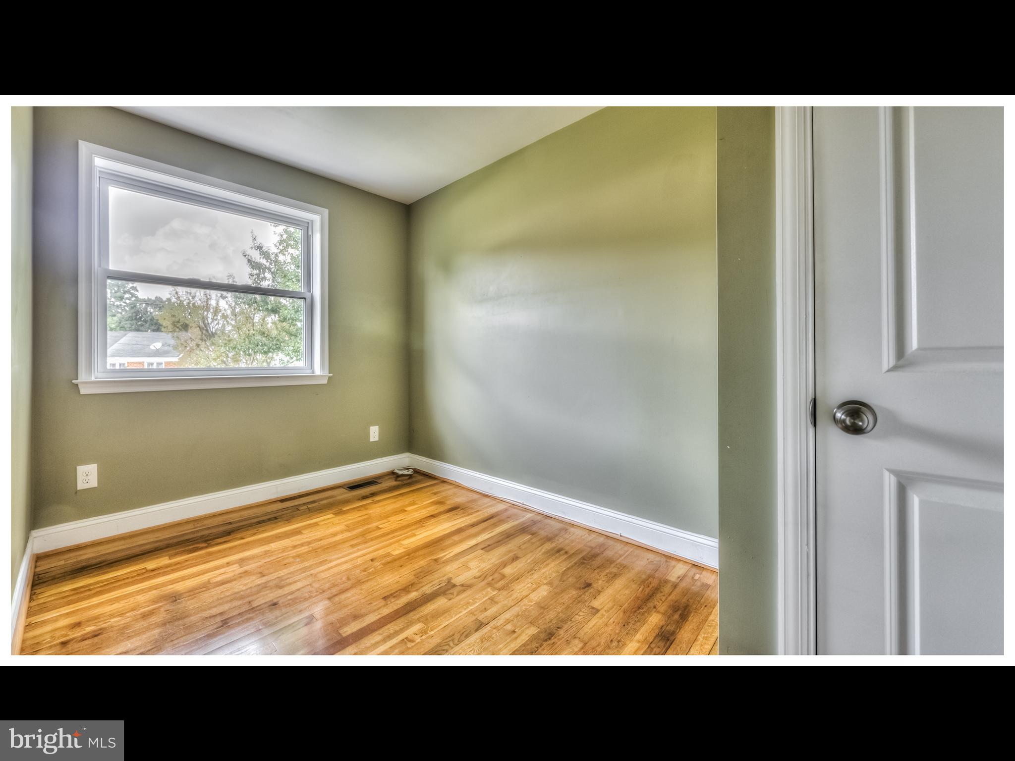 836 Bradhurst Road Baltimore, MD 21212 - Photo 16 of 24 a view of an empty room with wooden floor and a window