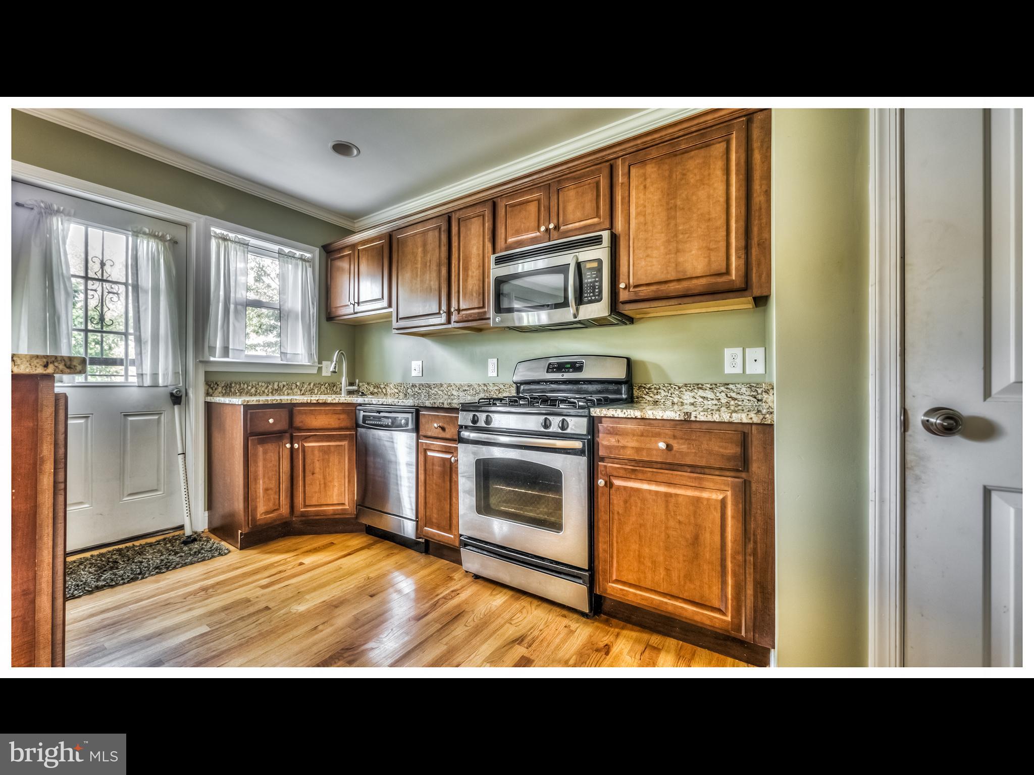 836 Bradhurst Road Baltimore, MD 21212 - Photo 7 of 24 a kitchen with stainless steel appliances granite countertop a stove a sink and a refrigerator