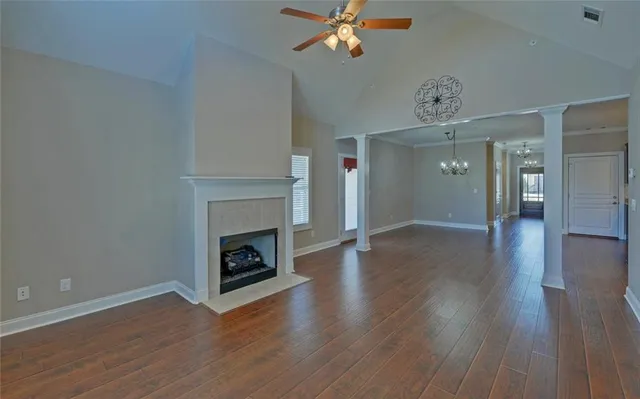 a view of a livingroom with a fireplace wooden floor and a chandelier fan