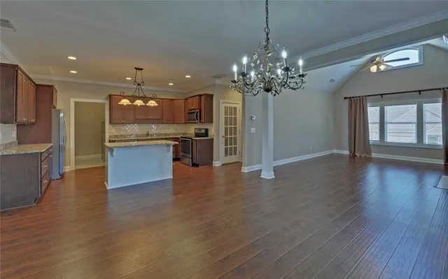 an open kitchen with a refrigerator and a stove top oven