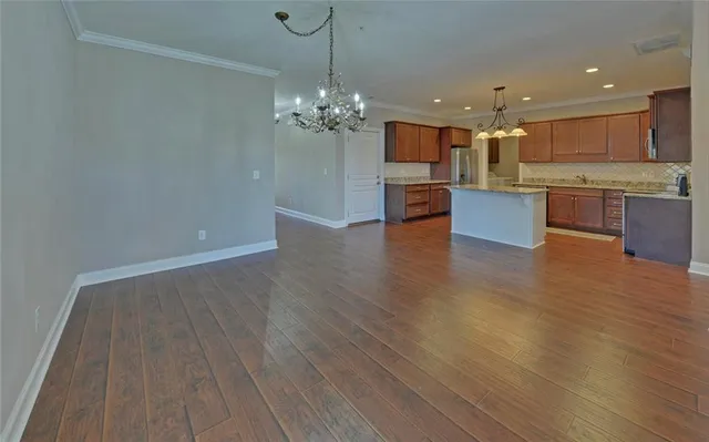 a view of kitchen with granite countertop cabinets and refrigerator