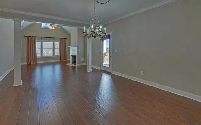 a view of a room with wooden floor and chandelier