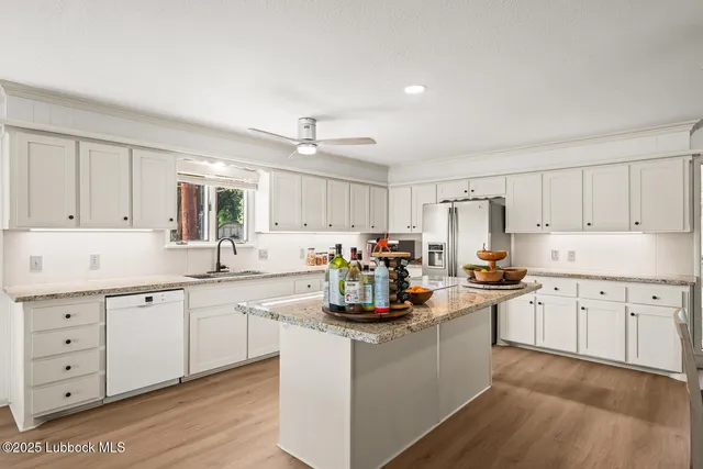 a kitchen with a dining table chairs and white appliances