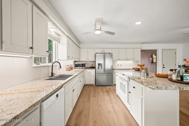 a kitchen with sink a stove and cabinets