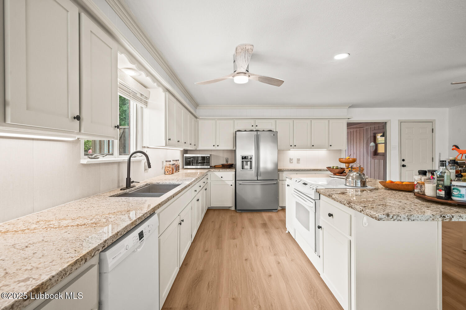 146 Pony Express Trail Buffalo Springs, TX 79404 - Photo 11 of 48 a kitchen with granite countertop a sink stove cabinets and refrigerator