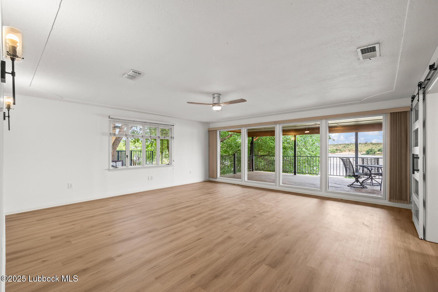 146 Pony Express Trail Buffalo Springs, TX 79404 - Photo 12 of 48 a view of an empty room with wooden floor and a window